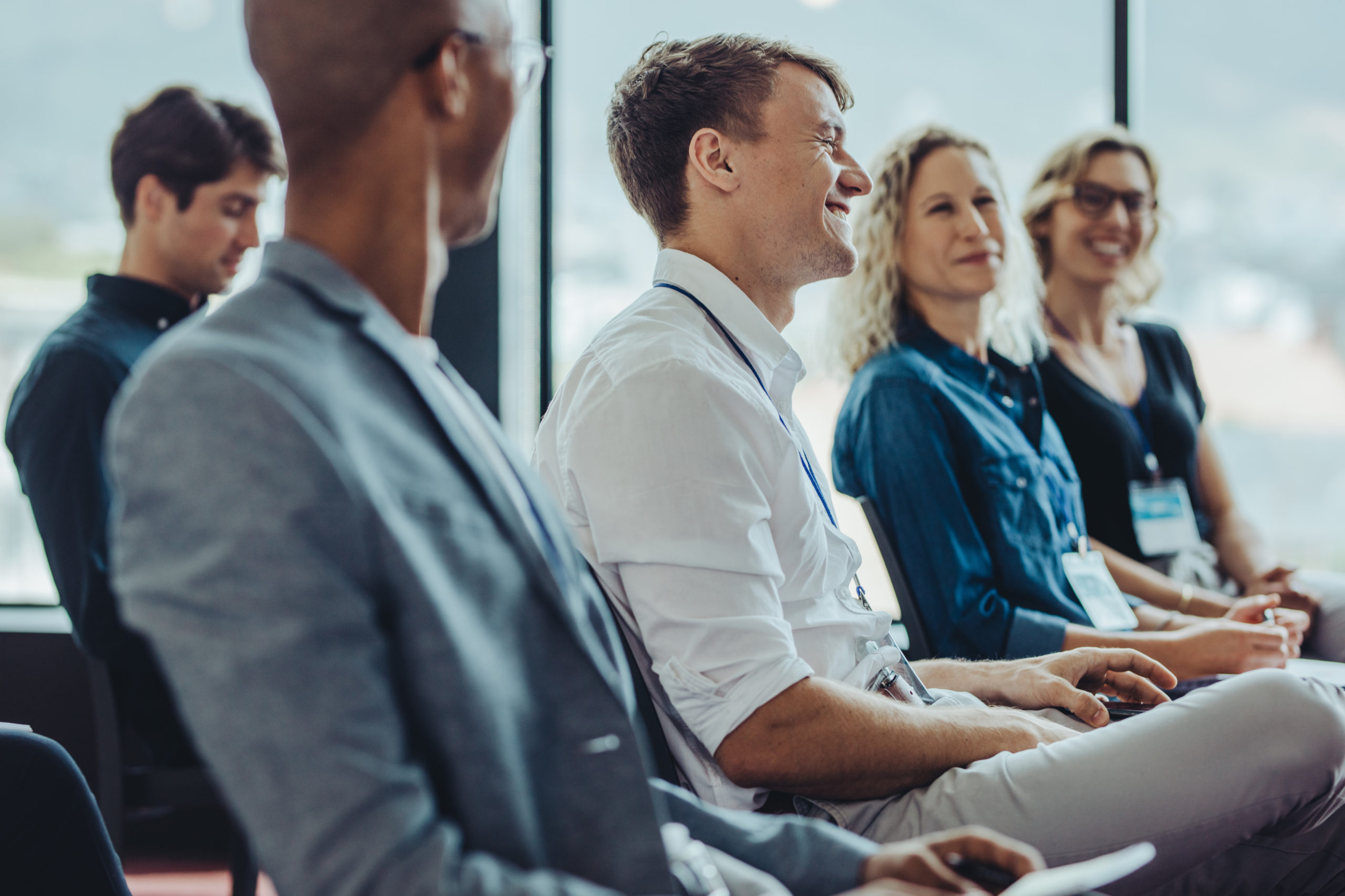 Businessmen and businesswomen sitting in audience. Group of multi-ethnic businesspeople sitting in a seminar.